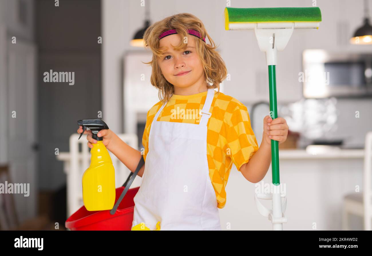Nettoyage des petits enfants à la maison. Enfant faisant des travaux ménagers s'amuser. Portrait d'une femme de ménage avec balai plat humide sur le fond intérieur de la cuisine. Banque D'Images