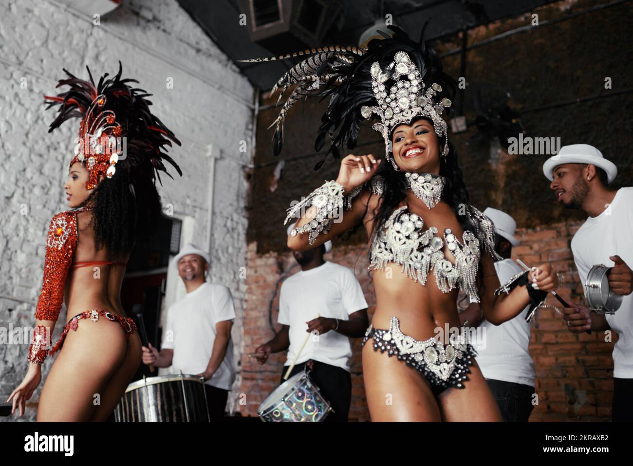 Ils vivent pour se produire. deux magnifiques danseurs de samba et leur groupe. Banque D'Images