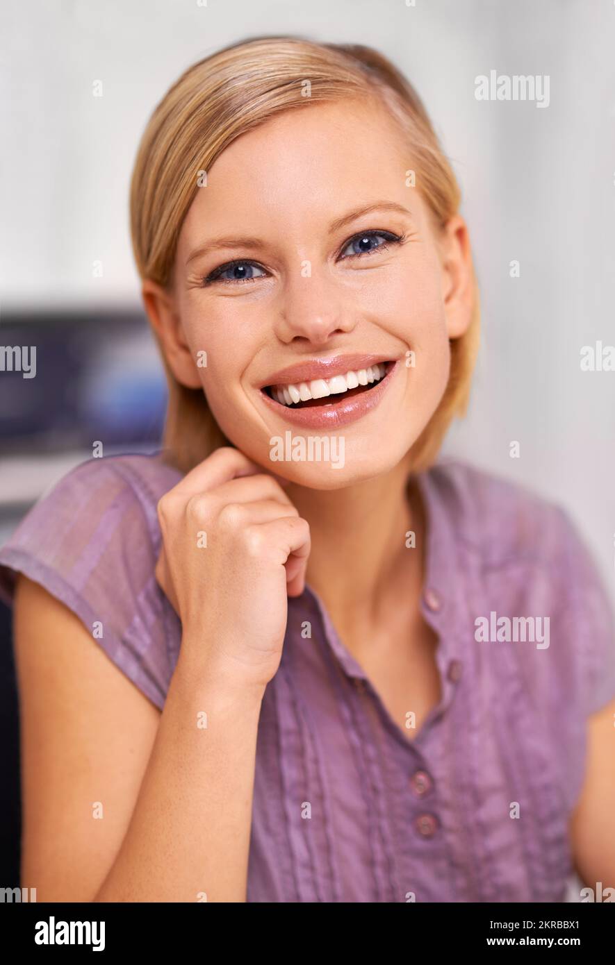 Garder les nerfs à l'épreuve. Portrait d'une jeune femme souriante et attrayante assise à un bureau. Banque D'Images