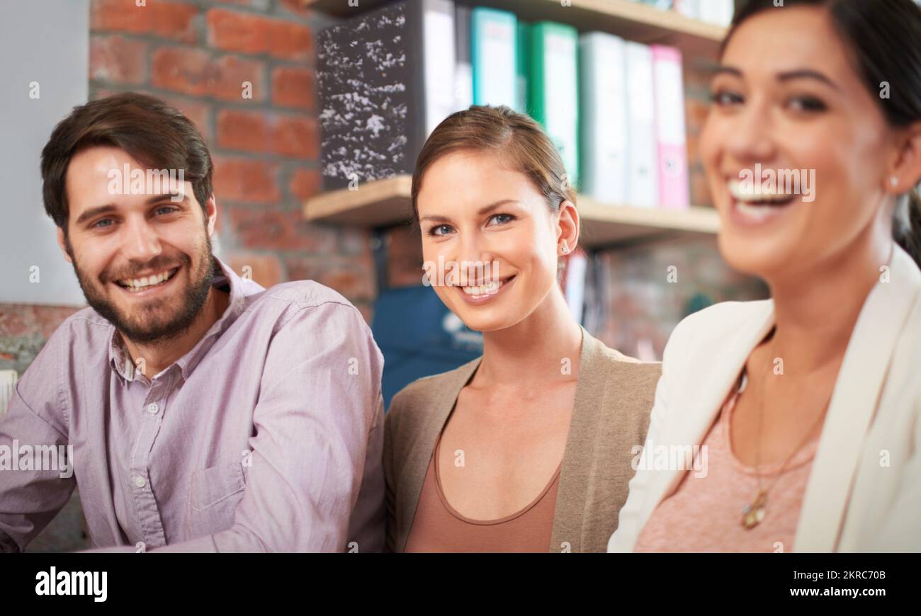 Faire le travail avec le sourire. trois collaborateurs travaillent ensemble sur un projet. Banque D'Images