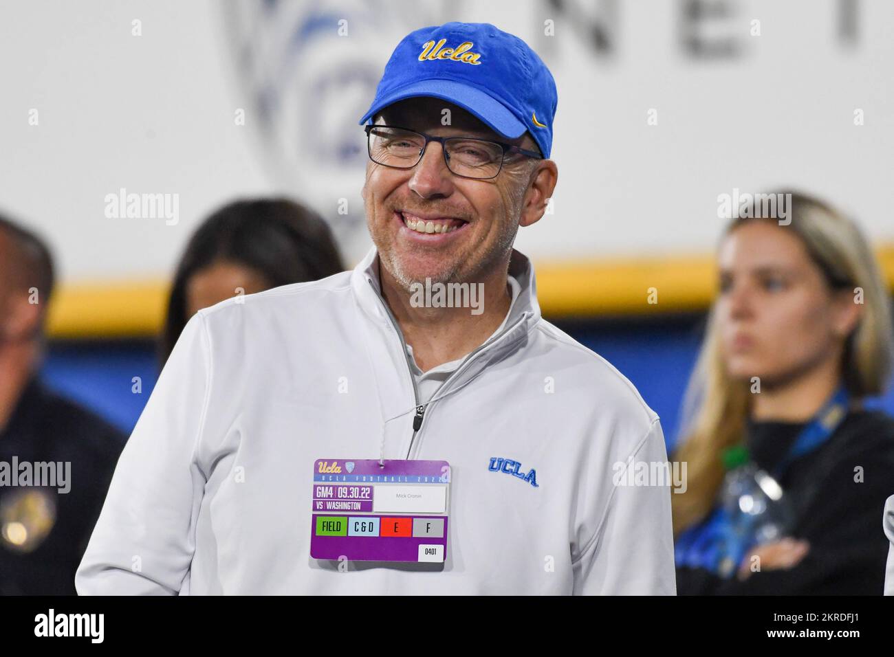 Mick Cronin, entraîneur en chef de basket-ball des Bruins d'UCLA, sourit sur le banc de touche 