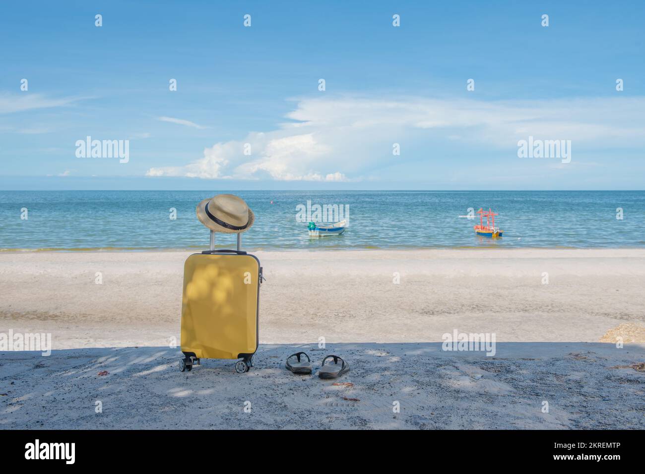 Valise de voyage avec chapeau sur la plage, concept de voyage et de détente. Banque D'Images