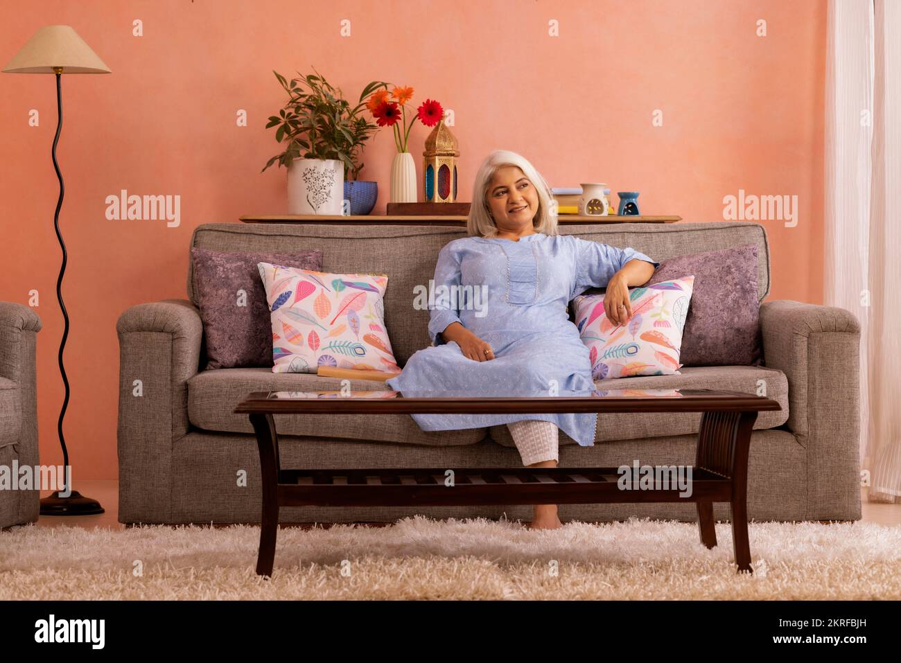 Portrait d'une vieille femme se reposant sur un canapé à la maison Banque D'Images