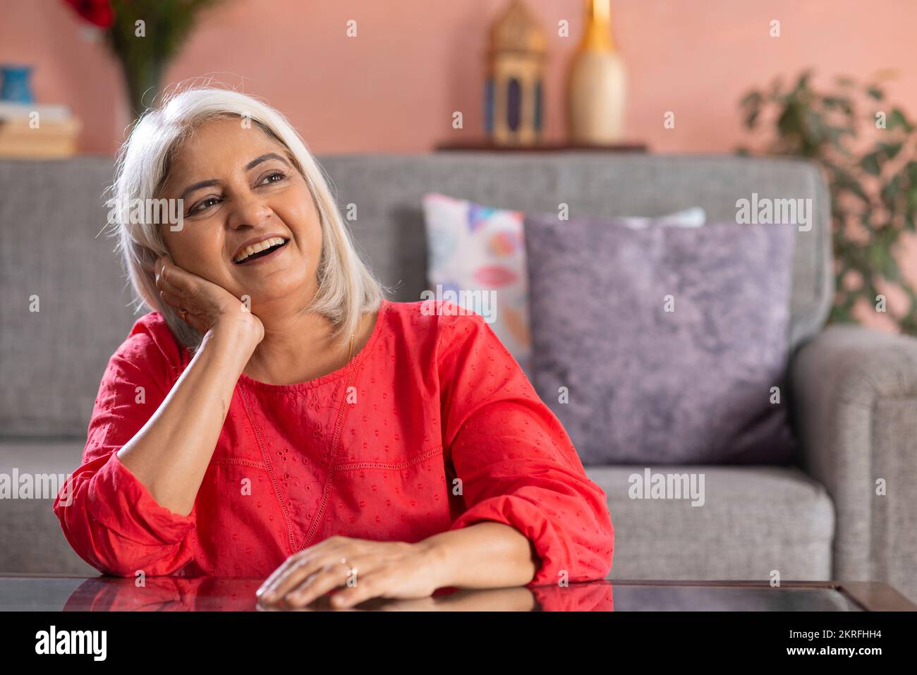 Portrait d'une vieille femme joyeuse regardant loin avec sa main sur la joue Banque D'Images