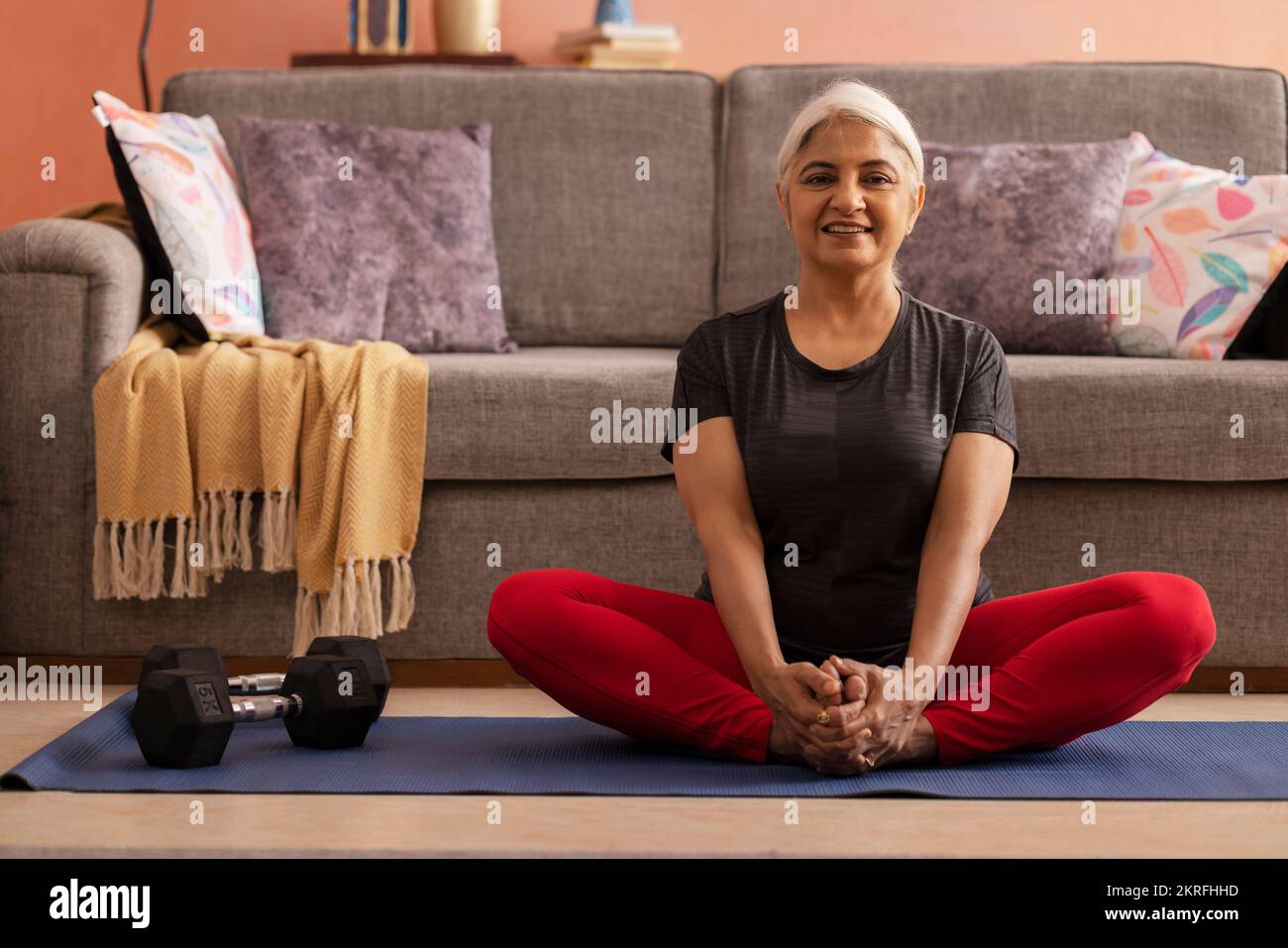 Portrait d'une vieille femme active pratiquant le yoga à la maison Banque D'Images
