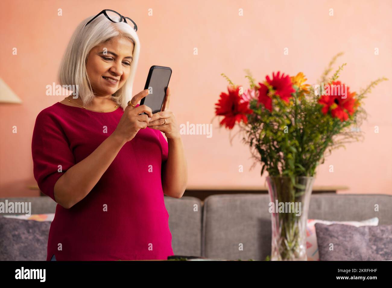 Portrait d'une vieille femme utilisant un téléphone portable à la maison Banque D'Images