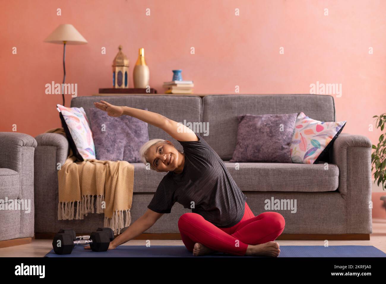 Portrait d'une vieille femme active pratiquant le yoga à la maison Banque D'Images