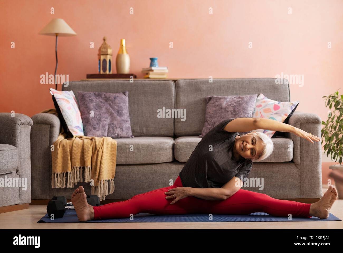 Portrait d'une vieille femme active pratiquant le yoga à la maison Banque D'Images