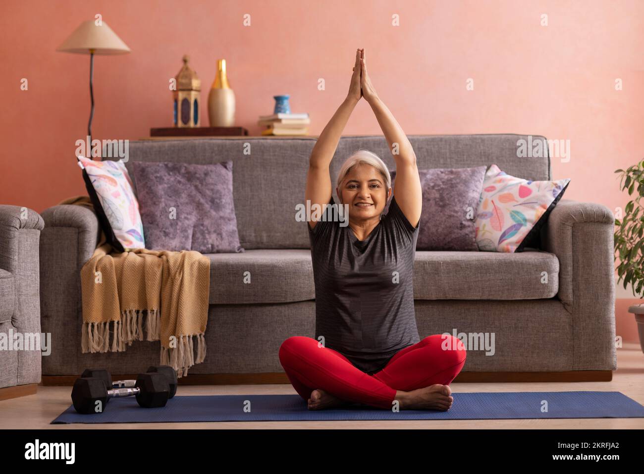 Portrait d'une vieille femme active pratiquant le yoga à la maison Banque D'Images