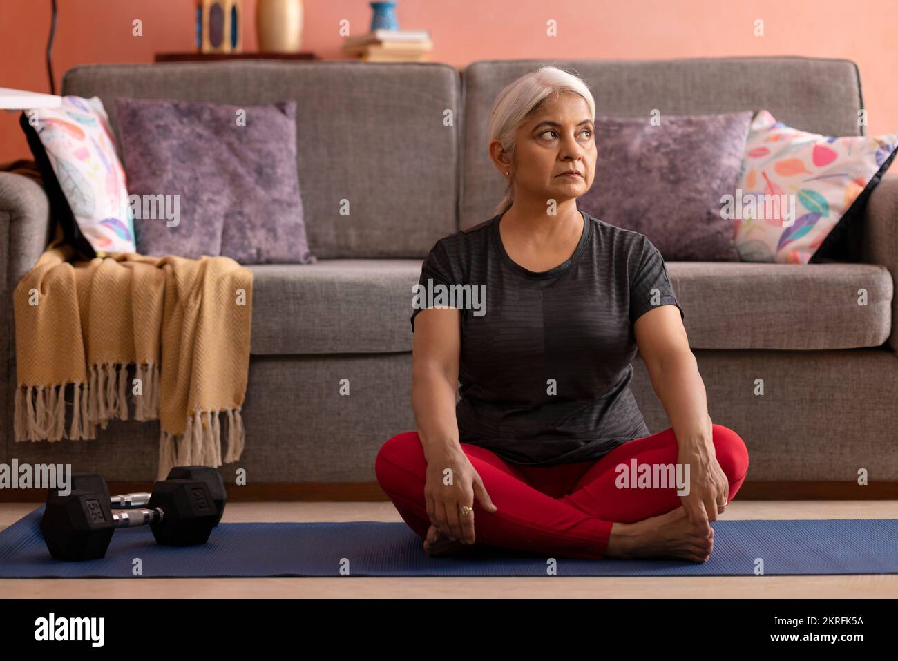 Portrait d'une vieille femme active pratiquant le yoga à la maison Banque D'Images