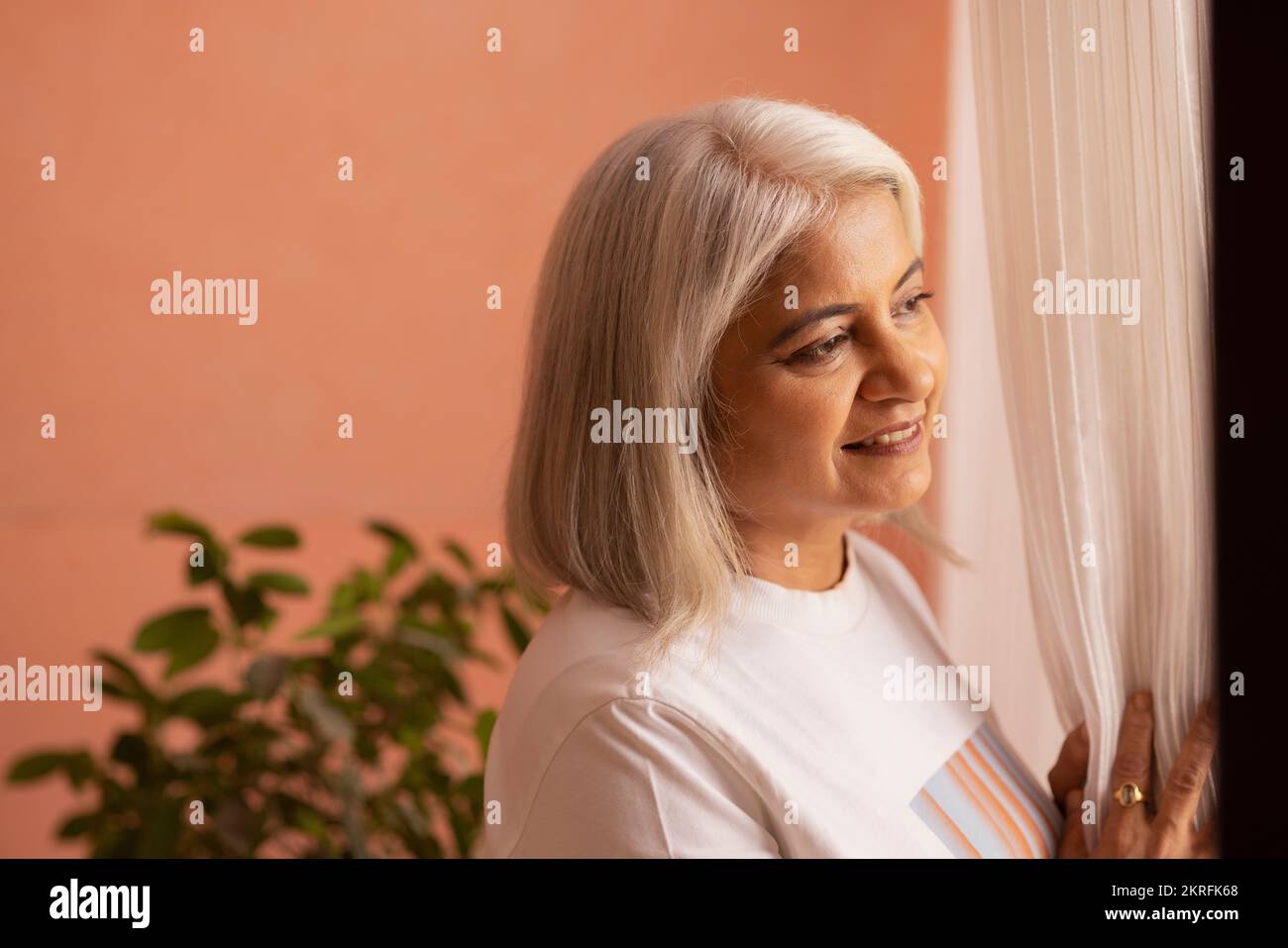 Portrait de la vieille femme en gros plan par la fenêtre Banque D'Images