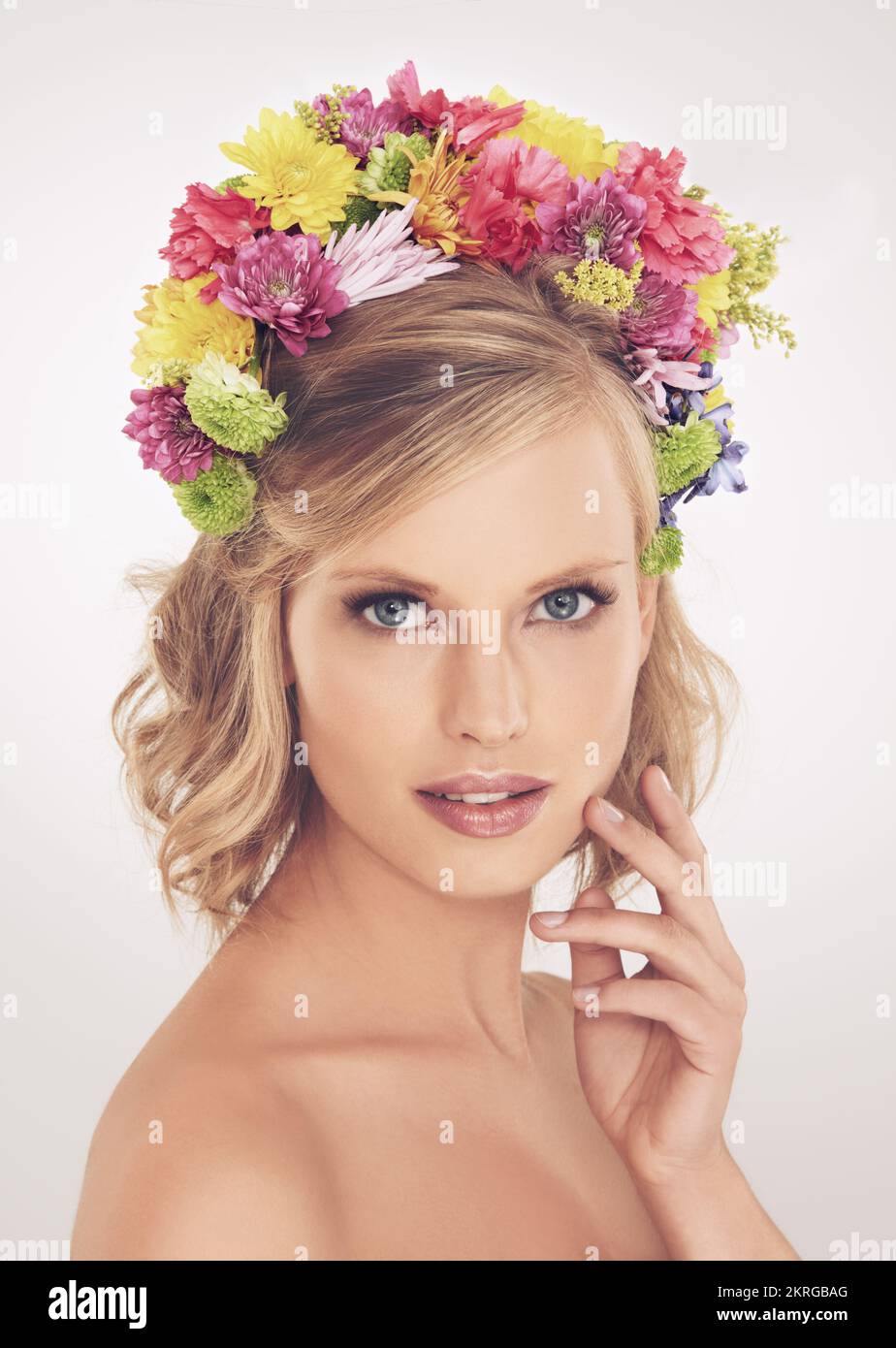 Déesse du printemps. Une jeune femme avec un arrangement de fleur dans ses cheveux souriant à la caméra. Banque D'Images