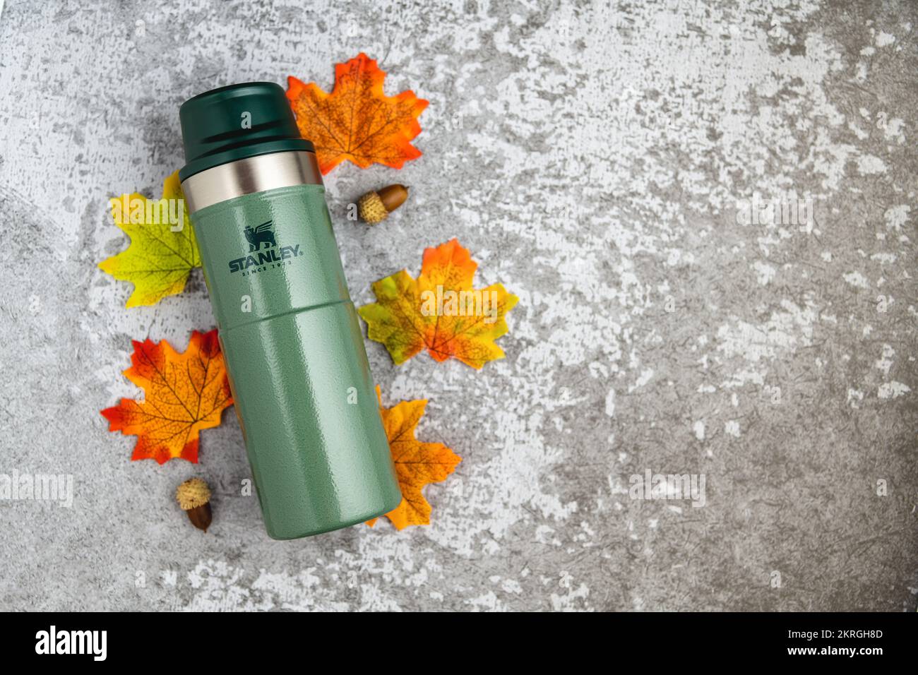 Antalya, Turquie - 28 novembre 2022: Stanley action Trigger thermos mug avec des feuilles dans les couleurs d'automne sur fond de pierre Banque D'Images