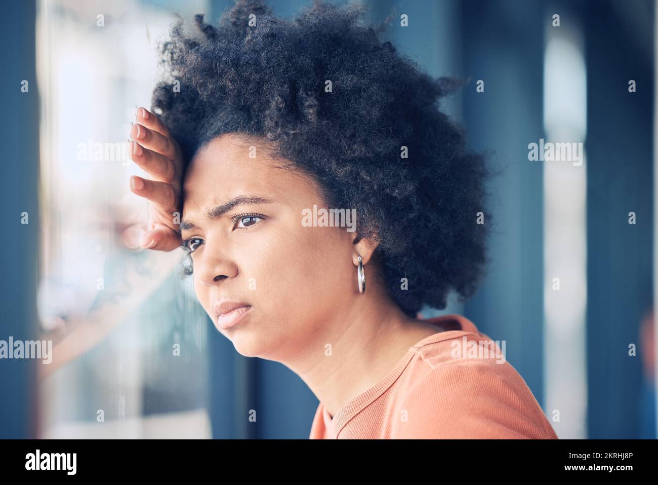 Femme triste, seule et déprimée à la fenêtre attendant, pensant et regardant dehors. Santé mentale, dépression et anxiété, femme noire avec problème Banque D'Images