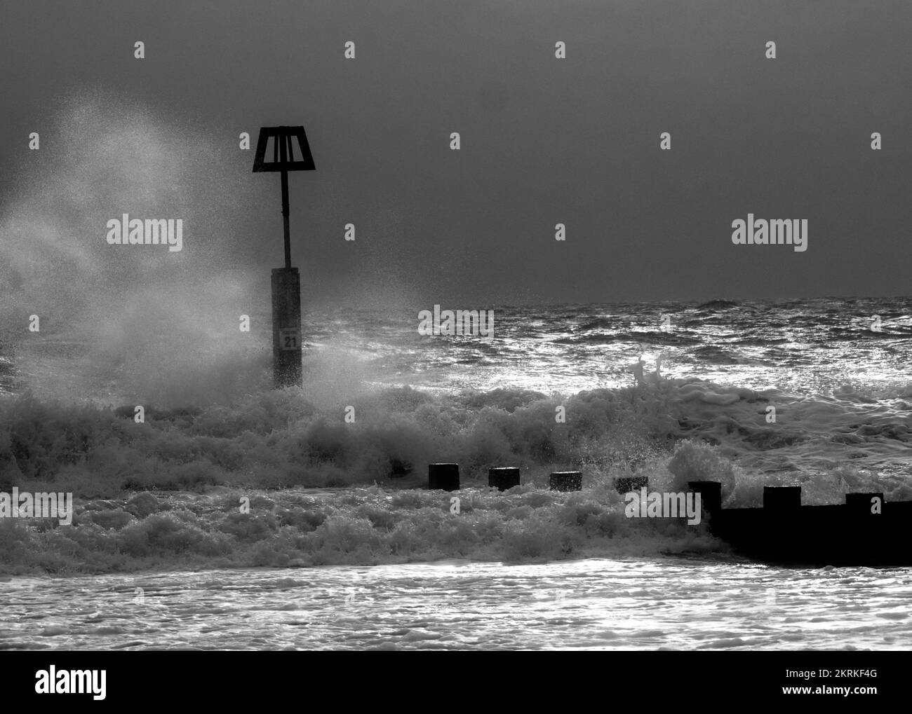 Vagues hivernales éclaboussant contre des marqueurs de groyne sur la plage de Boscombe, à Bournemouth Banque D'Images