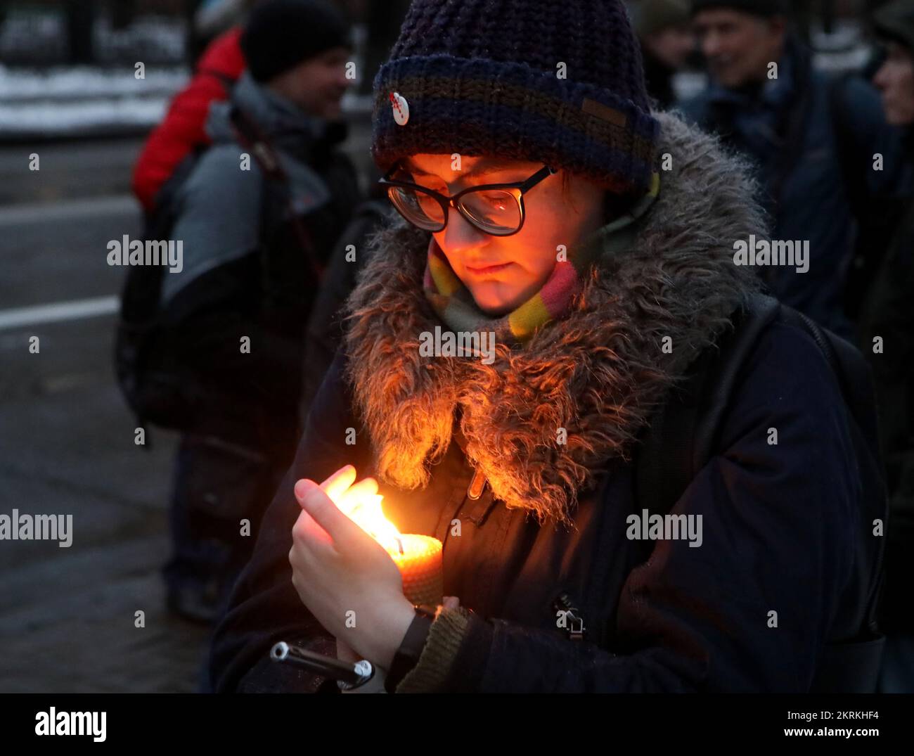 KIEV, UKRAINE - 26 NOVEMBRE 2022 - Une femme protège la flamme d'une bougie du vent pendant le souvenir. Unissons-nous ! Nous allons gagner ! événement commem Banque D'Images