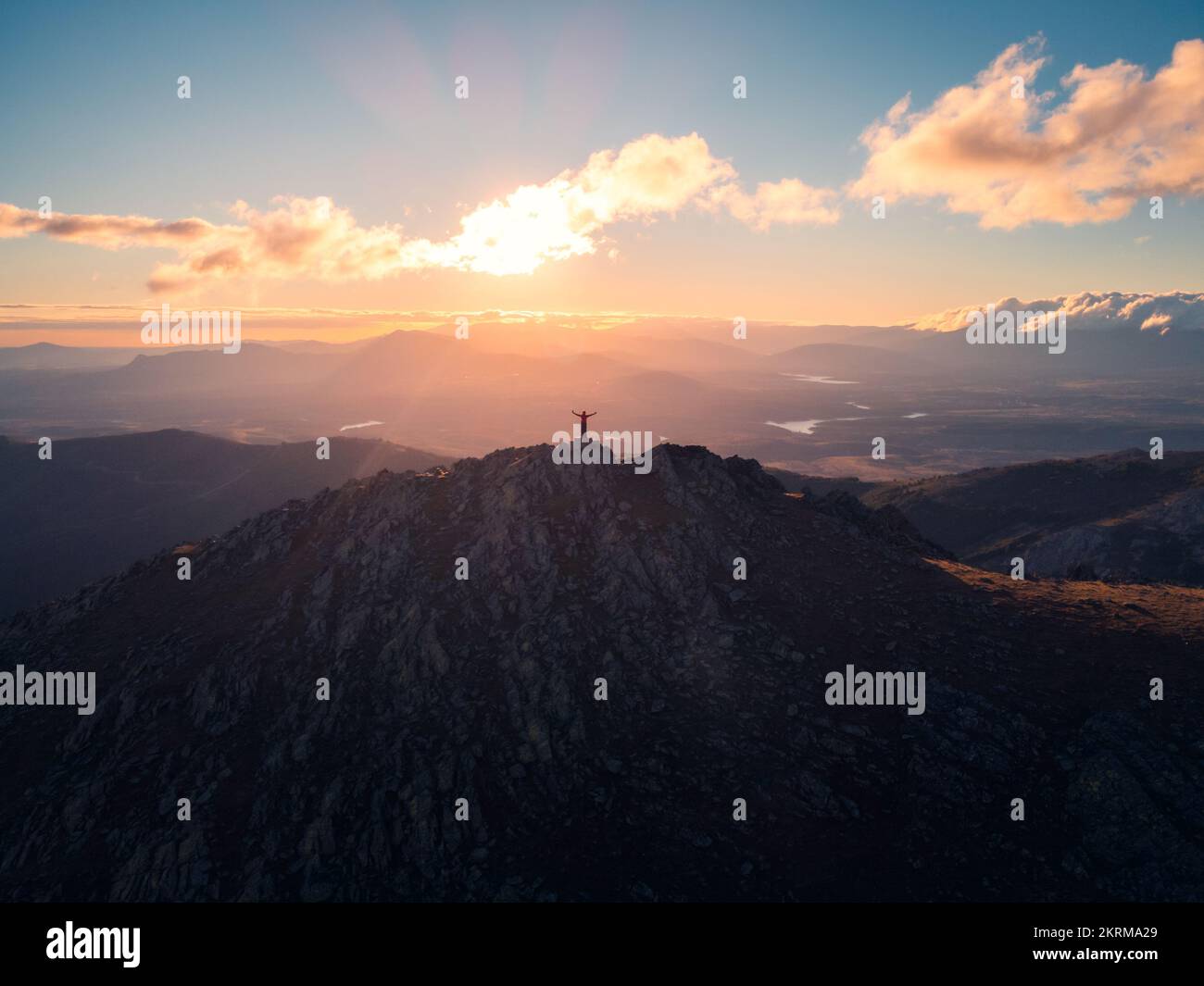 Solitaire de loin touristique dans le paysage majestueux avec la crête de la Sierra Norte traversant la vallée sous ciel clair avec des nuages au coucher du soleil, Espagne Banque D'Images