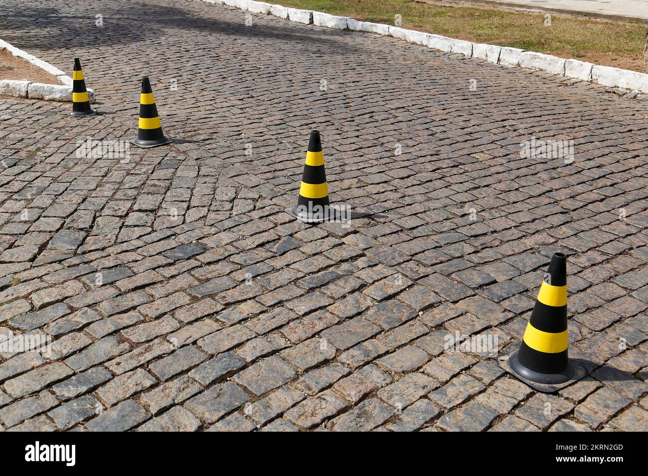 feu de signalisation de couleur jaune et noire, plastique dur, sur la voie publique en pierre Banque D'Images