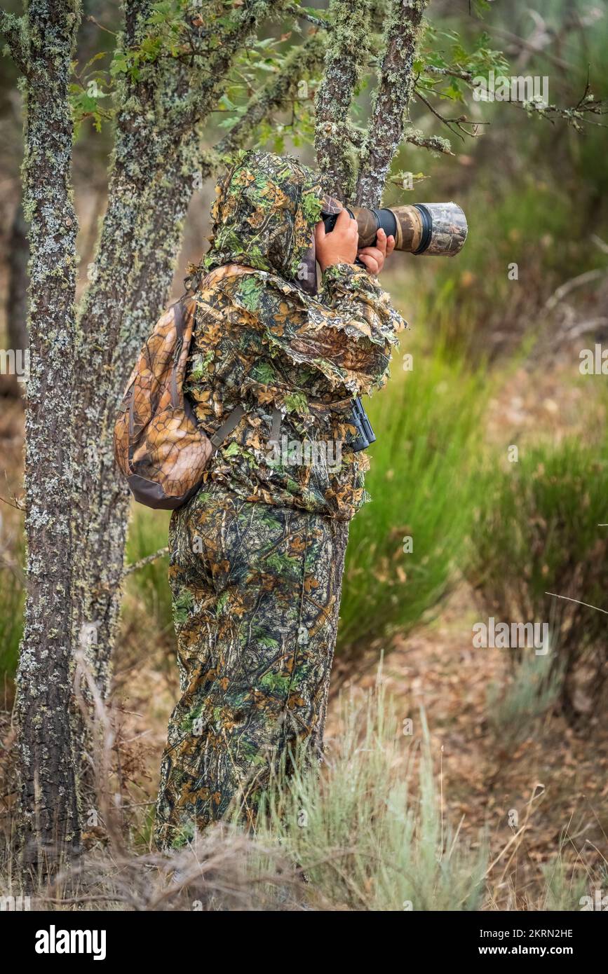 Photographe vêtu d'un costume de camouflage prenant des photos Banque D'Images