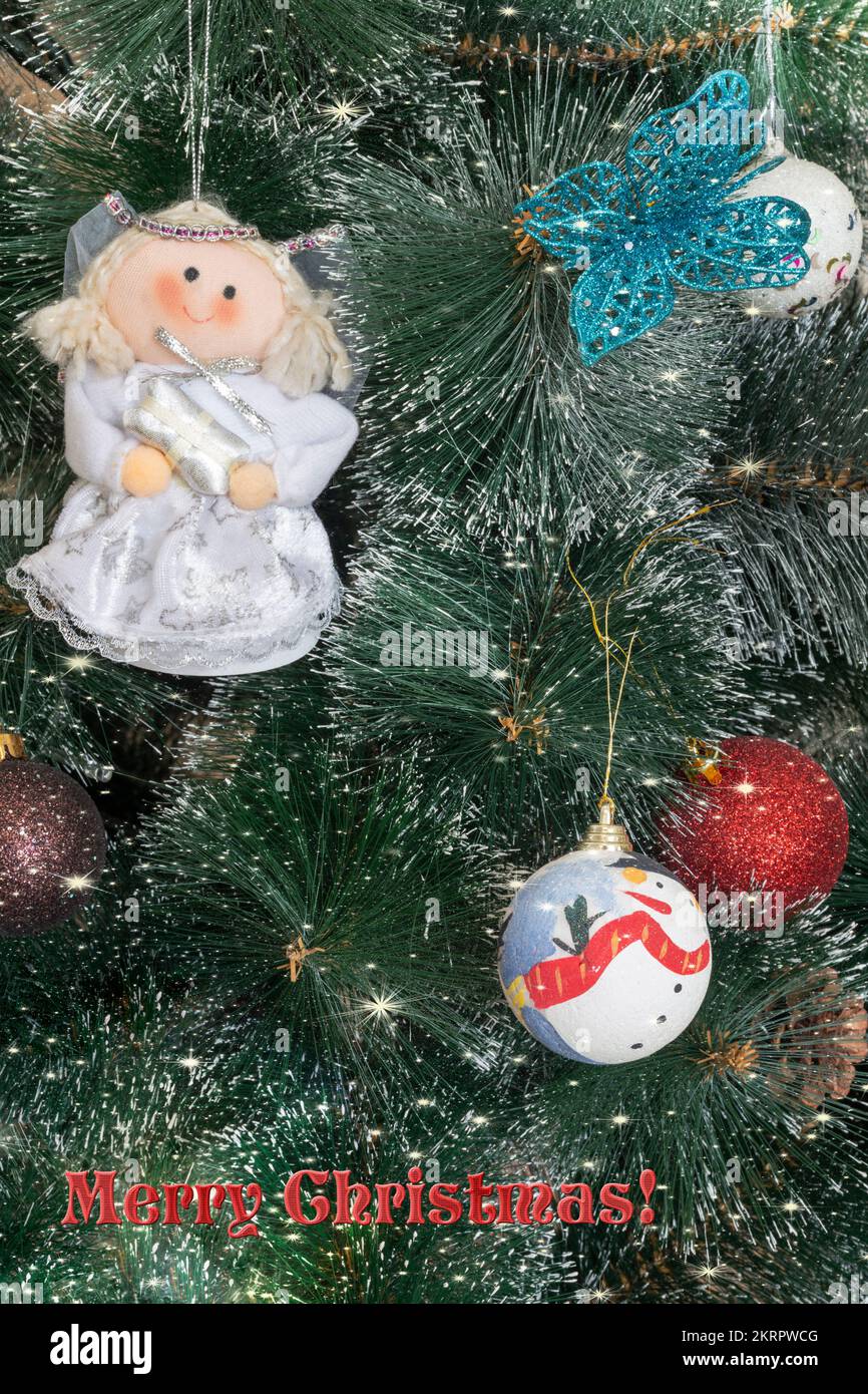 Magnifique fond avec bokeh et flocons de neige pour une carte de vœux de Noël avec des décorations sur les branches de l'arbre et un message de bienvenue. Banque D'Images