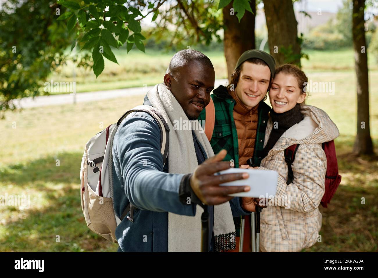 Groupe d'amis souriants prenant des photos de selfie dans la nature tout en appréciant la randonnée ensemble Banque D'Images