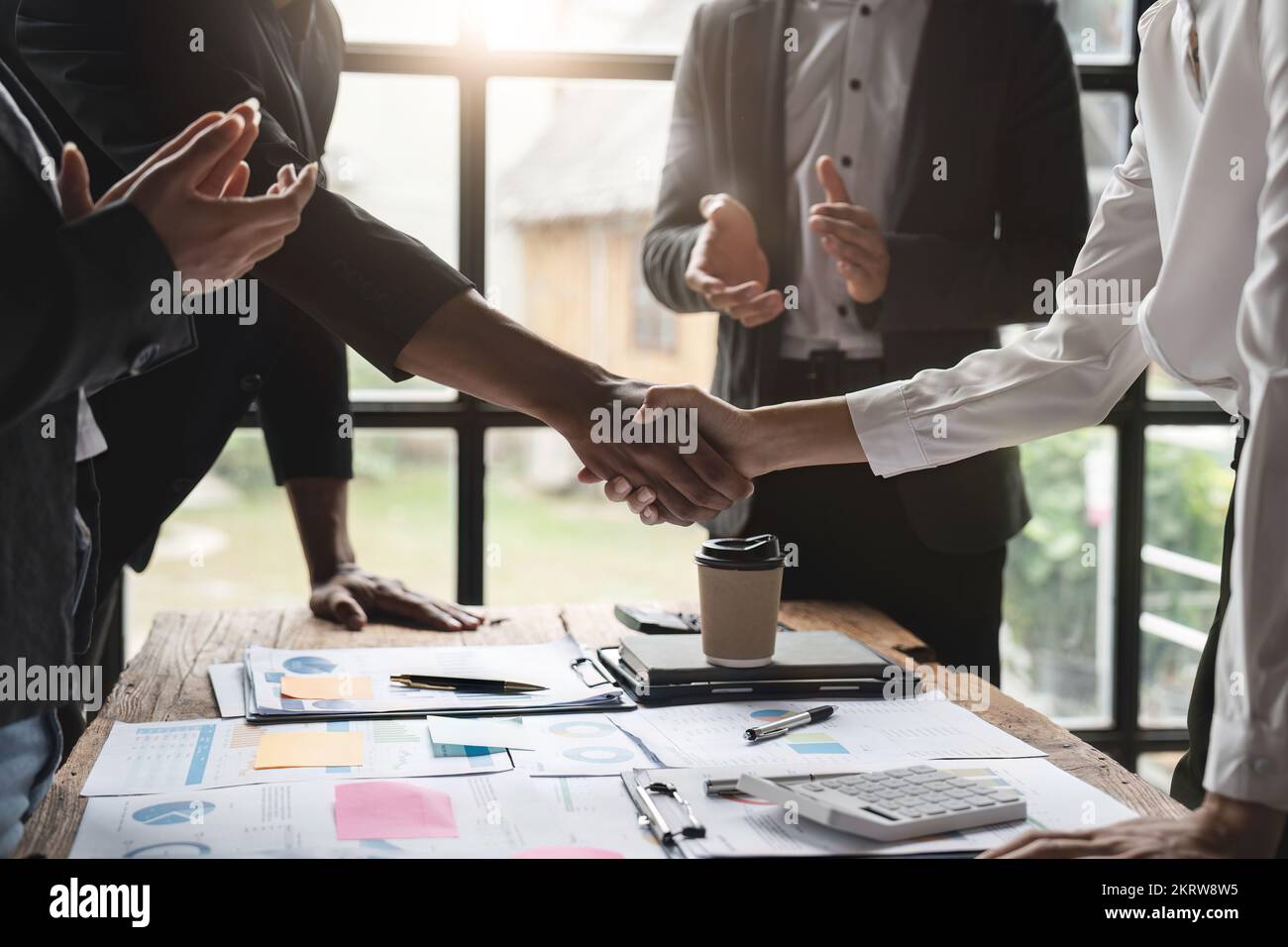 Les gens d'affaires de groupe sont en mesure de se mettre à la table de réunion au bureau en toute confiance.Les jeunes hommes d'affaires et les femmes d'affaires expriment leur accord Banque D'Images