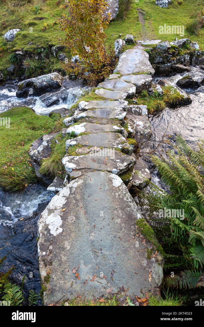 Ruisseau qui coule sous une passerelle en pierre Snowdonia Nord du pays de Galles Banque D'Images