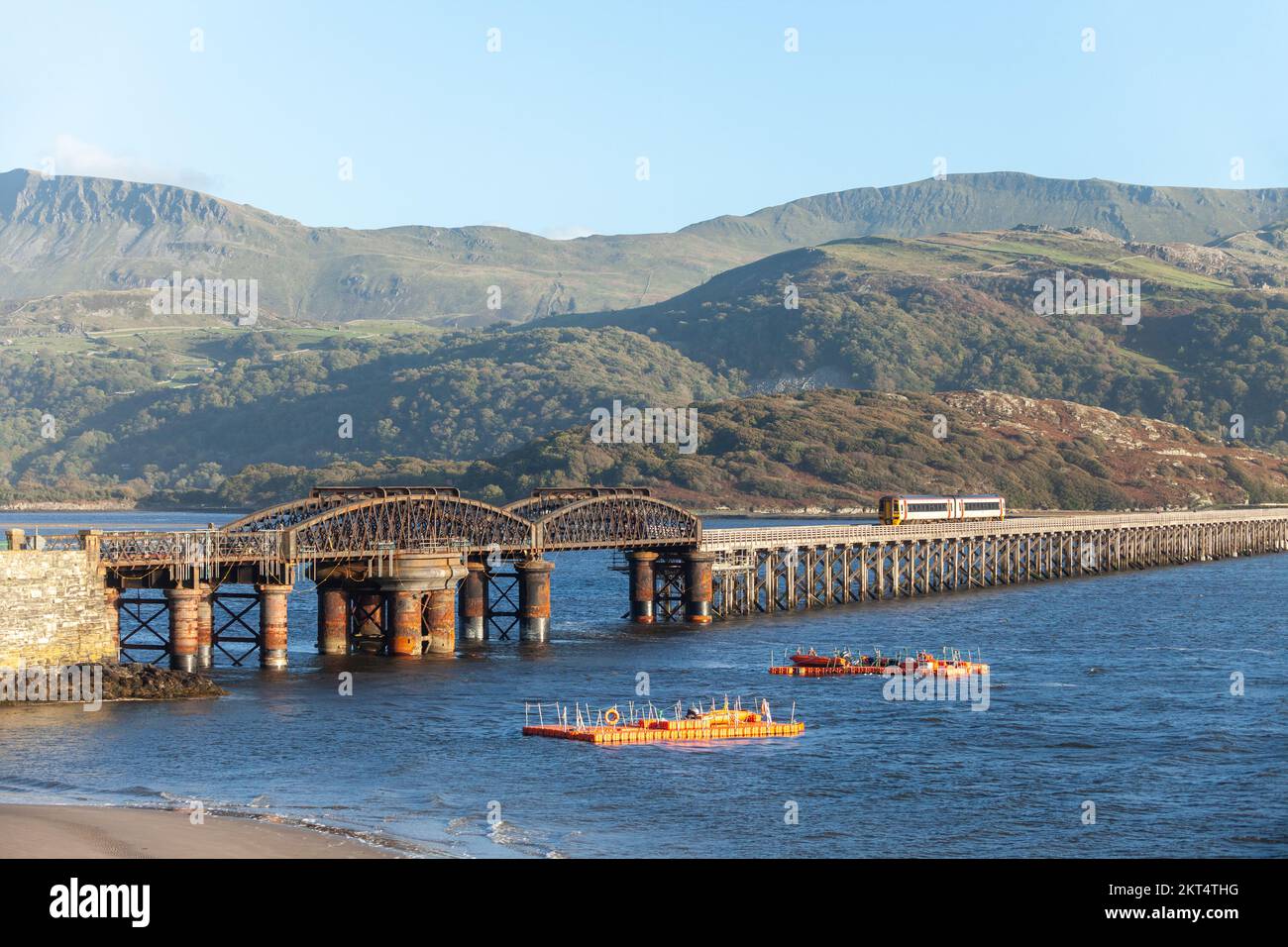 Un train traversant le pont à péage de Barmouth en traversant la rivière Afon Mawddach, Barmouth, Gwynedd, pays de Galles, Royaume-Uni Banque D'Images