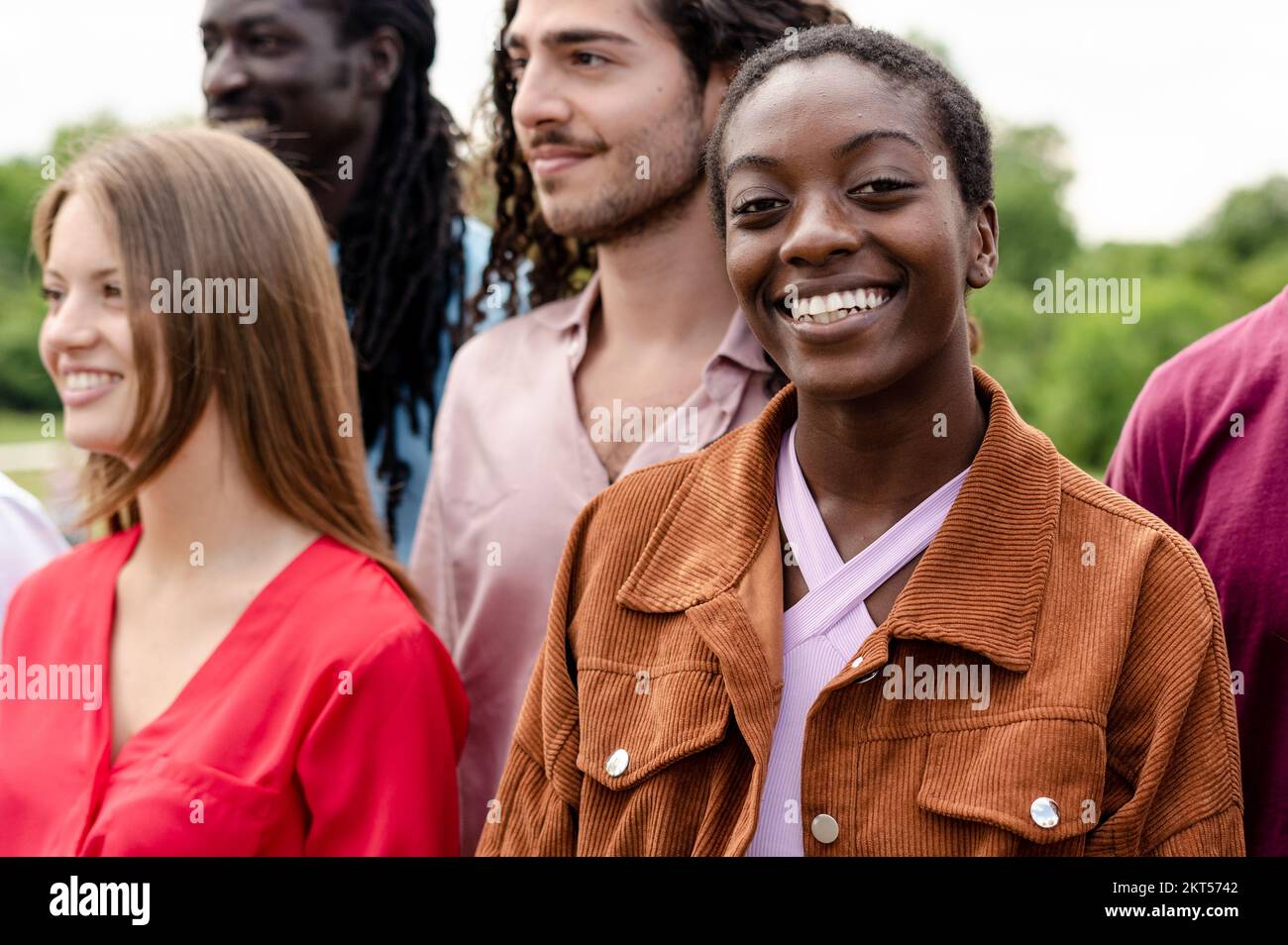 Groupe multiculturel d'amis s'amusant à la campagne, fille africaine souriant regardant la caméra Banque D'Images