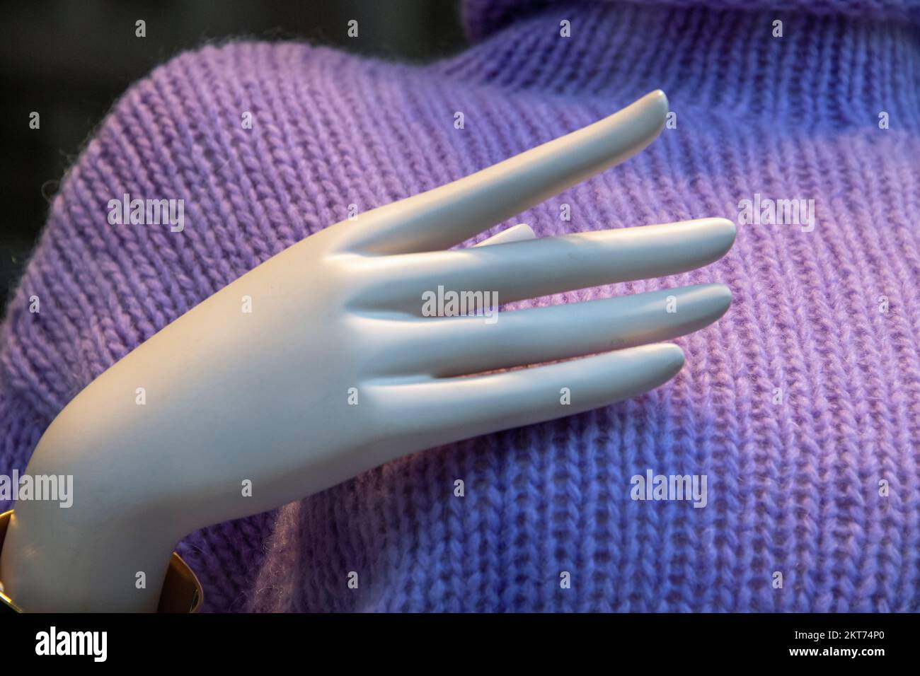 Main d'une figurine de mode vêtue d'un pull-over à tricoter Banque D'Images