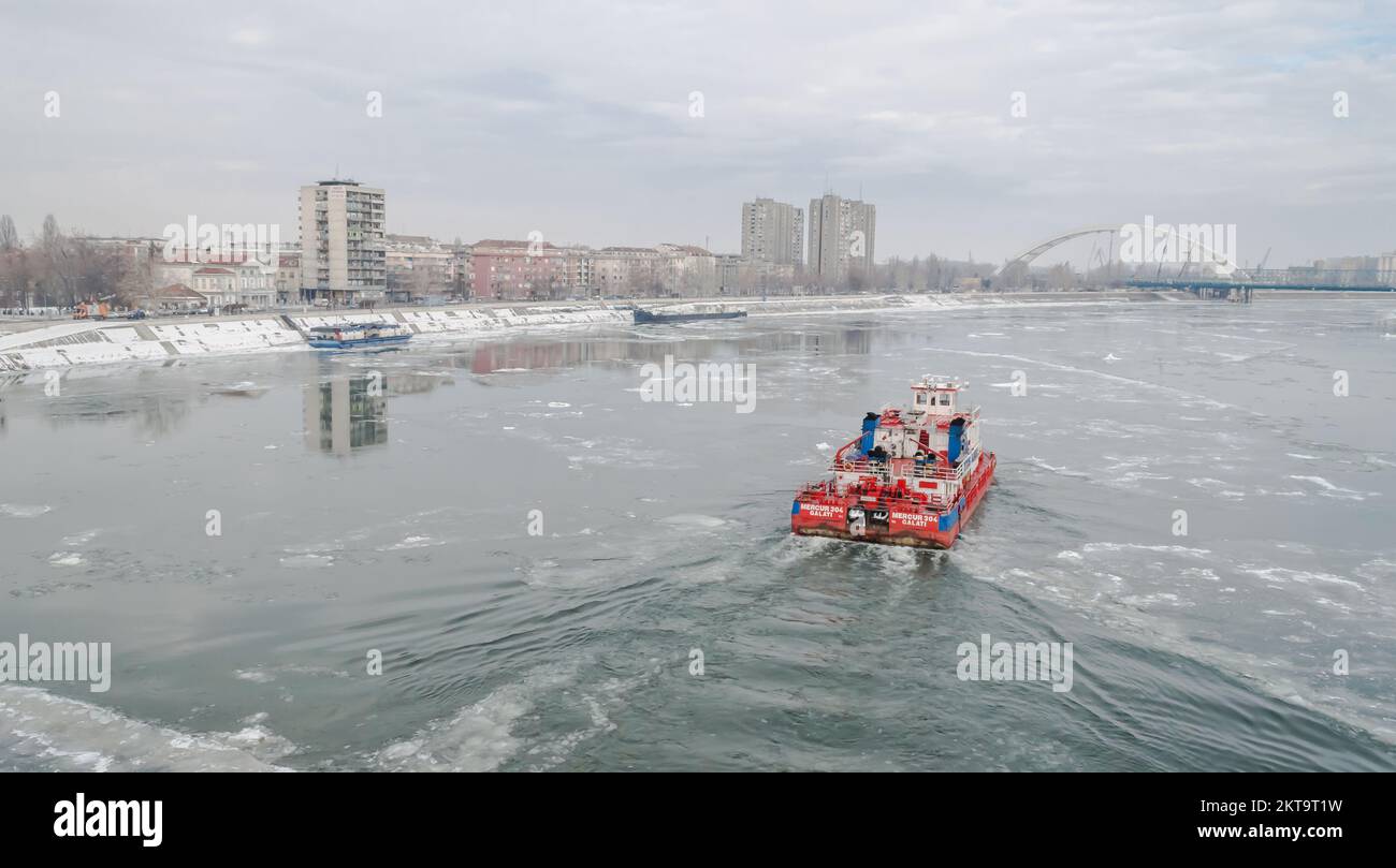 Danube recouvert de neige et de glace. Navire brise-glace dans la voie navigable gelée et enneigée du Danube, sous la forteresse de Petrovaradin Banque D'Images