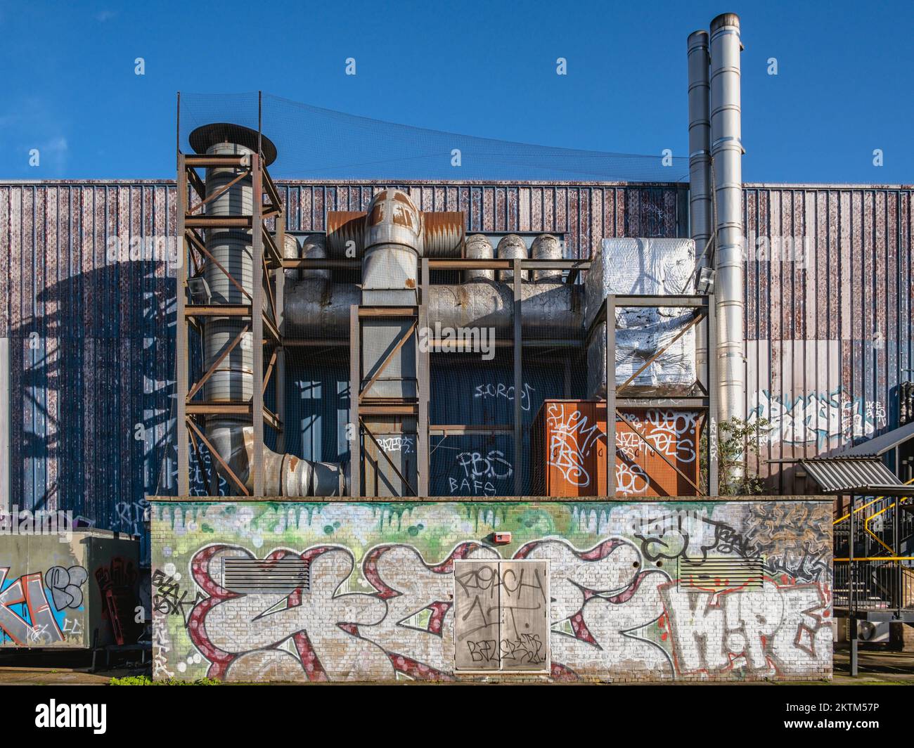 Grands tuyaux de climatisation industriels à l'extérieur de l'entrepôt de Londres. Tuyaux, cheminées, Graffiti, Londres. Banque D'Images