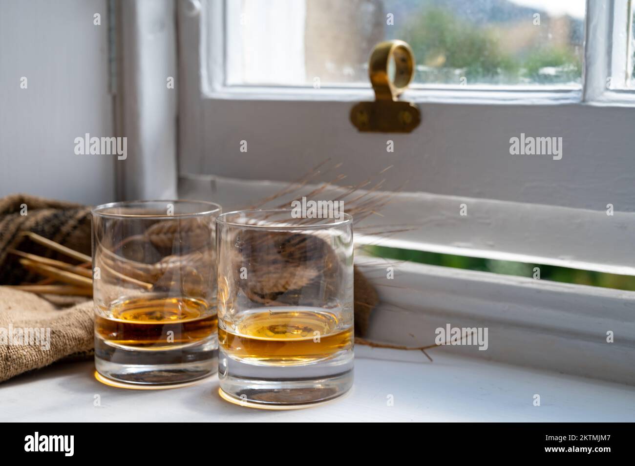 Deux verres de whisky single malt scotch servis sur un vieux rebord de fenêtre en bois blanc dans la maison Scottisch à Édimbourg, en Écosse, au Royaume-Uni Banque D'Images