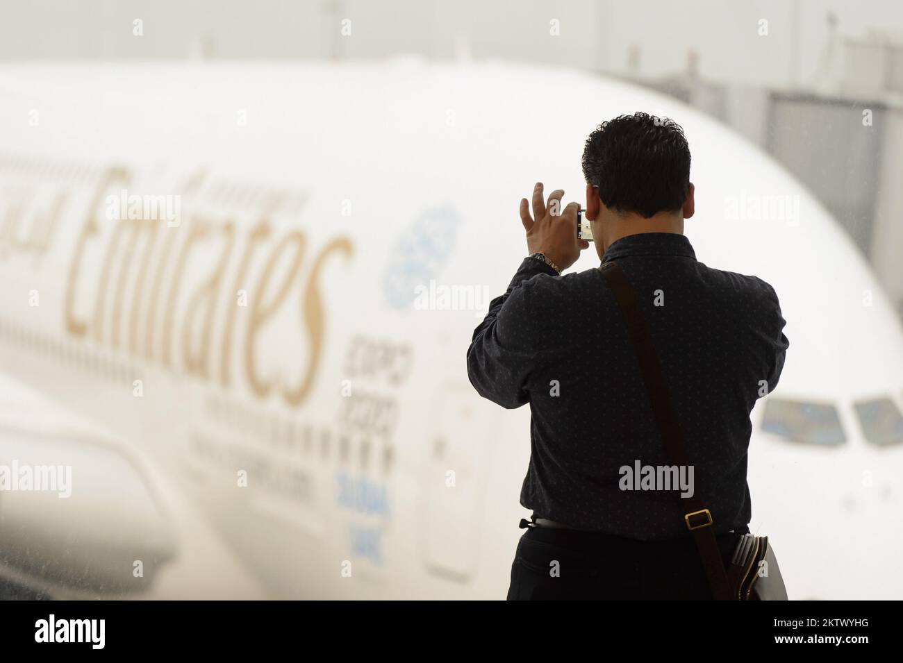 HONG KONG - 09 MARS 2015 : homme prenant des photos de l'Airbus A380 ancré  dans l'Emirates. Emirates gère la majeure partie du trafic passagers et des  mouvements d'avions a Photo Stock -