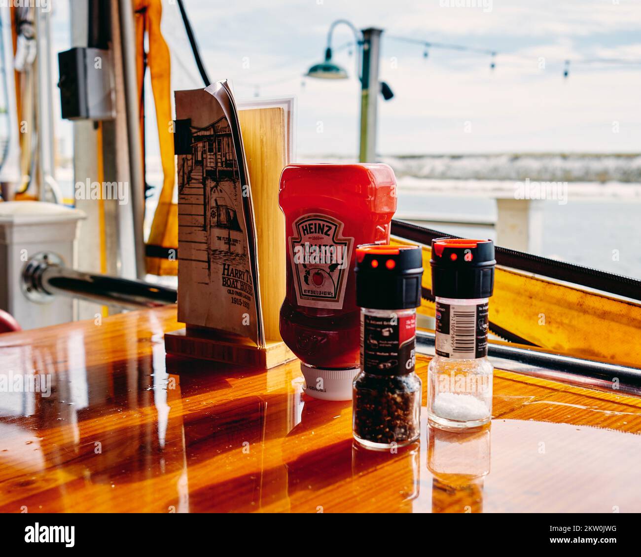 Le ketchup à condiments, le sel et le poivre avec un menu de boissons sur une table de restaurant à destin Floride, Etats-Unis. Banque D'Images