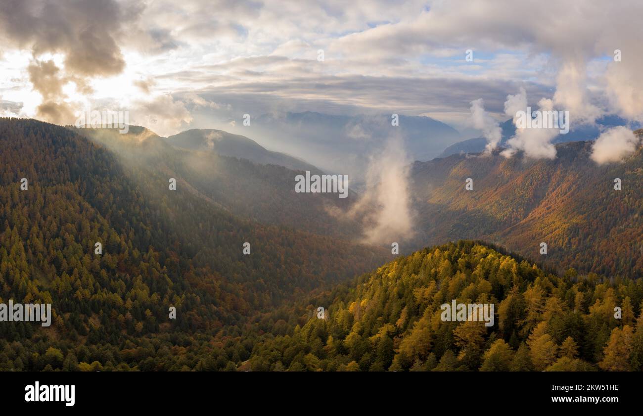 Vue aérienne sur la Valle dArbedo en automne, avec les rayons du soleil se brisant à travers les nuages, Canton du Tessin, Suisse, Europe Banque D'Images