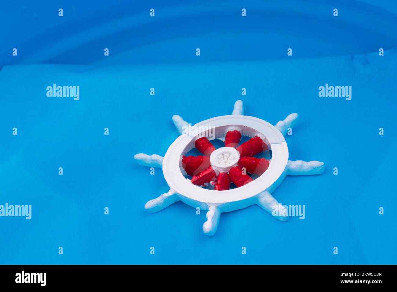 Petit modèle de couleur rouge et blanc volant bateau dans l'eau Banque D'Images