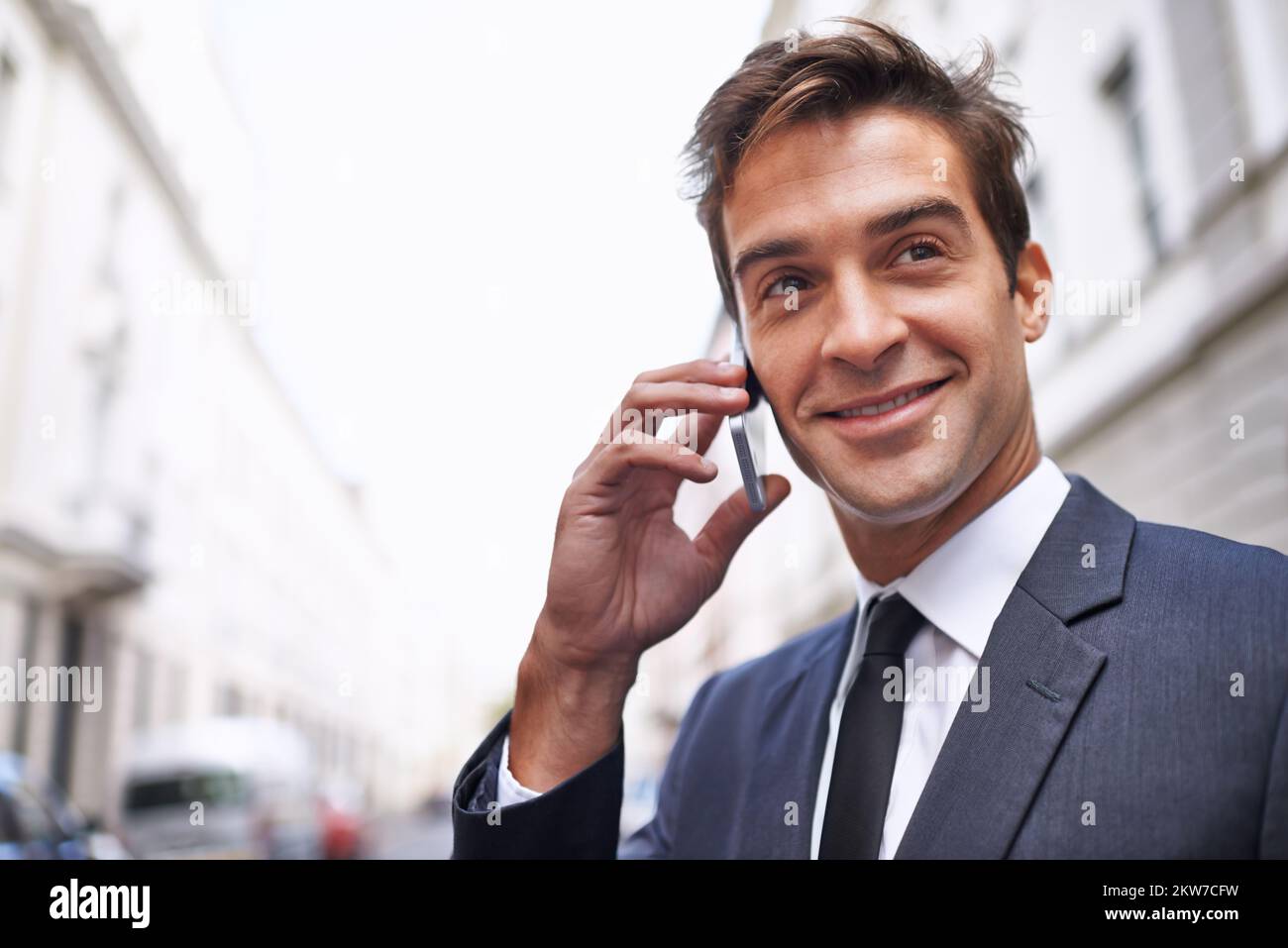 Im dans la ville. Un beau homme d'affaires en costume parlant sur son téléphone portable dans la ville. Banque D'Images
