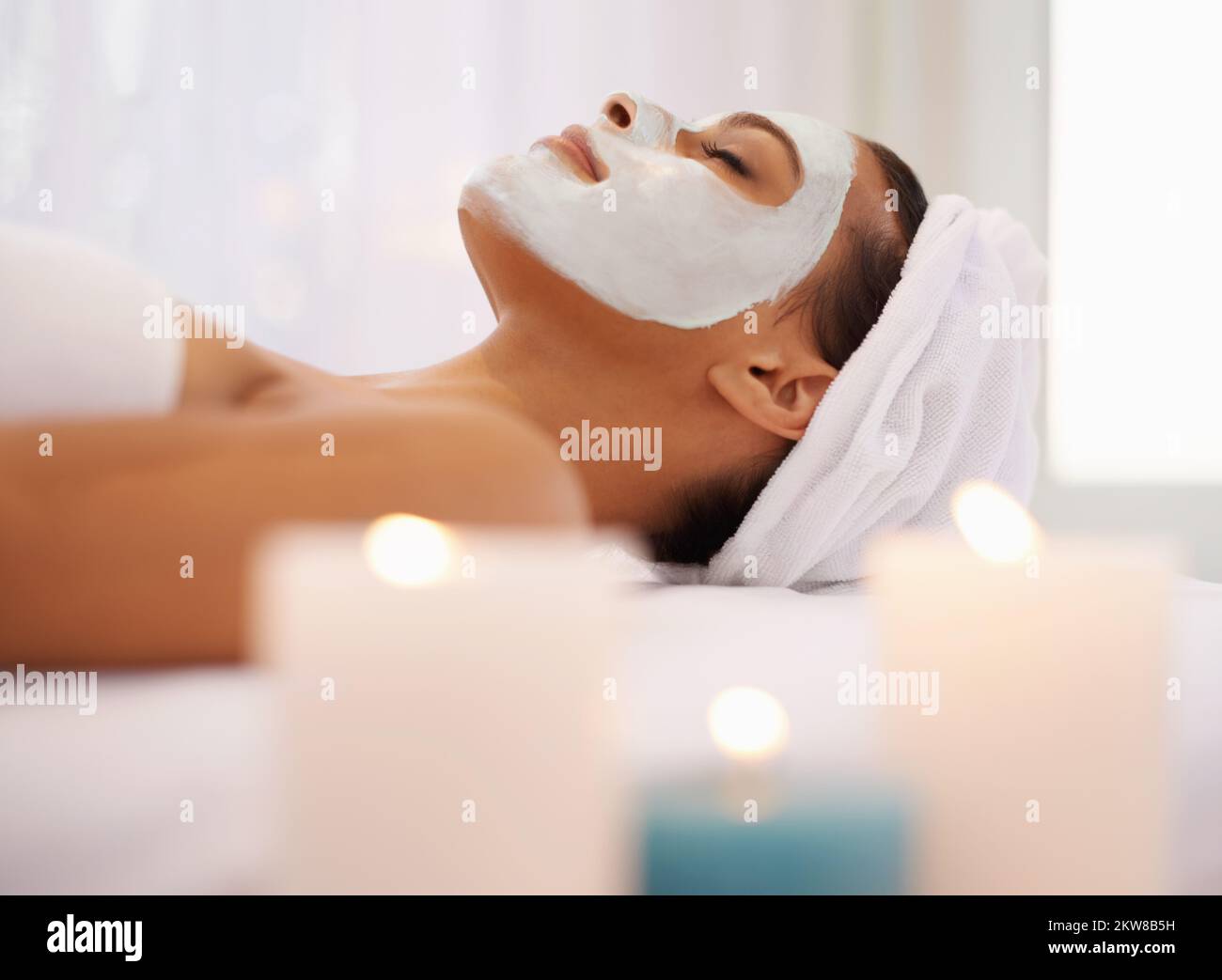 Même quand elle est jeune, chaque petit peu aide... une jeune femme qui profite d'un soin du visage au spa. Banque D'Images