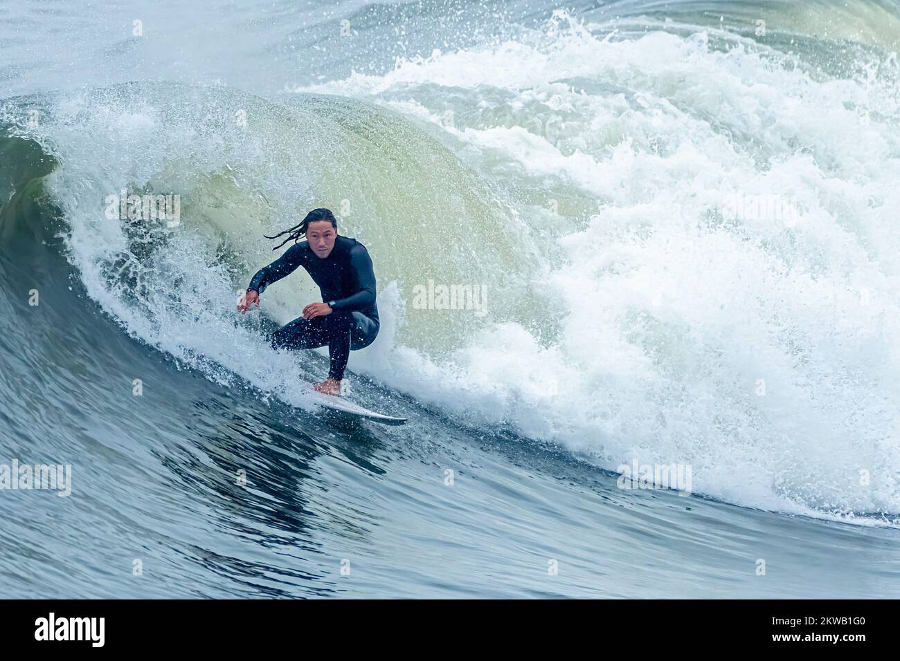 Surfeur à cheval sur une houle à la fin de l'automne près de la jetée de Jacksonville Beach à Jacksonville Beach, Floride. (ÉTATS-UNIS) Banque D'Images