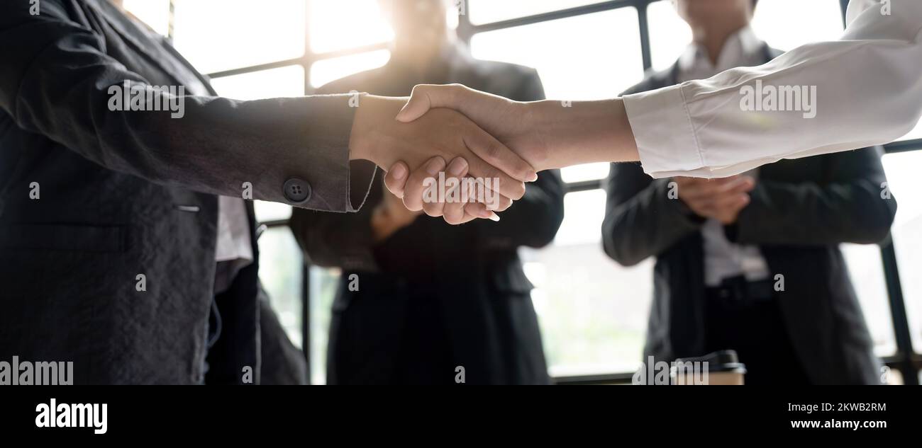 Les gens d'affaires de groupe sont en mesure de se mettre à la table de réunion au bureau en toute confiance.Les jeunes hommes d'affaires et les femmes d'affaires expriment leur accord Banque D'Images