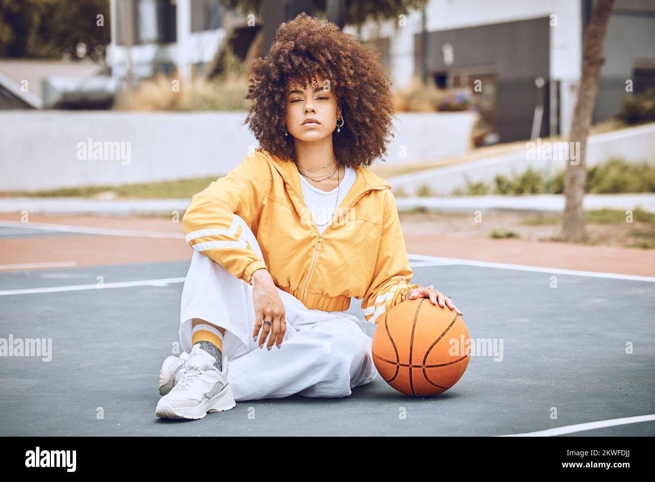 Jeune, à la mode et belle femme noire joueur de basket-ball ou athlète avec  afro assis sur un terrain. Portrait de la personne fraîche et edgy dans un  Photo Stock - Alamy