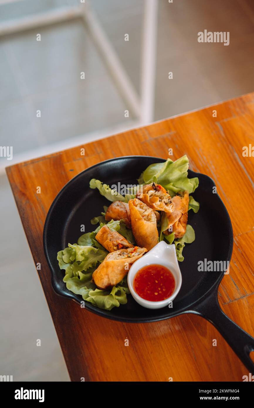 Magnifique cuisine thaïlandaise sur une assiette. Rouleaux de printemps  avec des sauses épicées, du riz au poulet et des crevettes frites sur un  riz frit. Un dîner asiatique délicieux et délicieux Photo