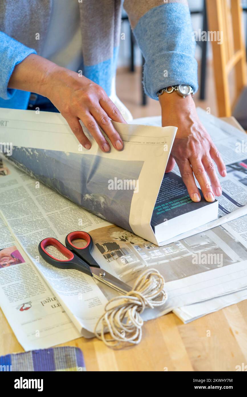 Emballage-cadeau durable, dans les journaux, sans ruban adhésif, juste attaché avec le cordon, Banque D'Images