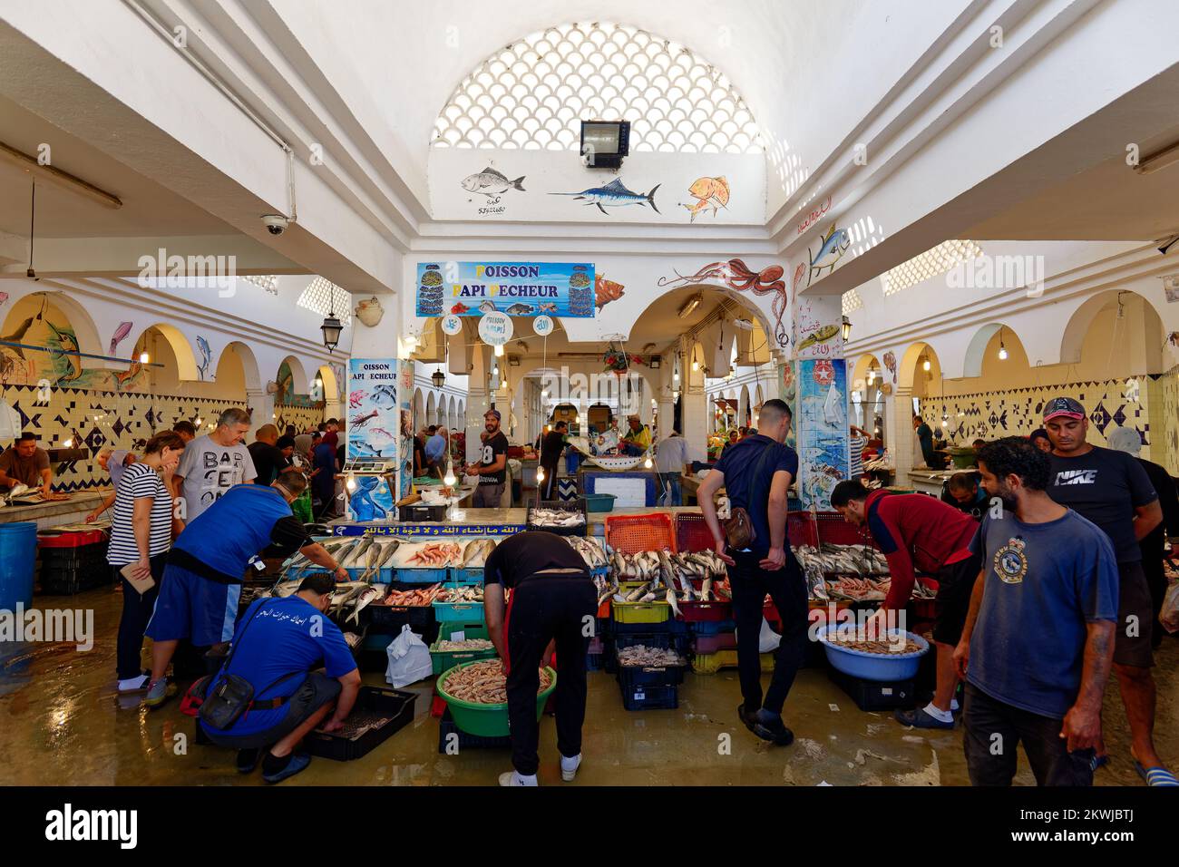 Marché aux poissons dans la vieille ville de Médina de Sousse en Tunisie. Groupe de personnes magasiner pour le poisson dans un marché traditionnel. Zone côtière. Banque D'Images