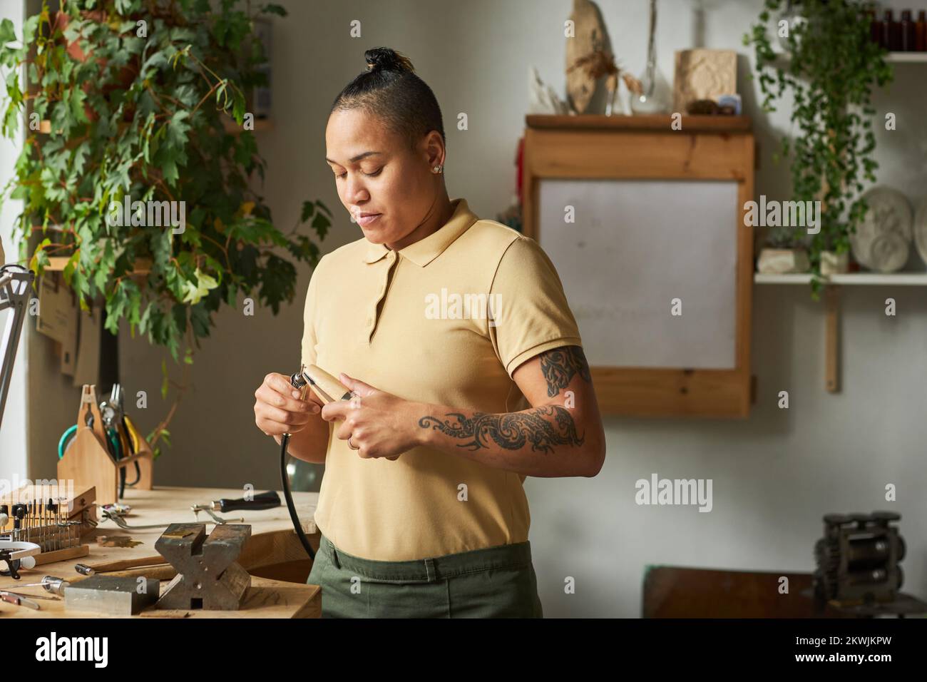 Portrait d'une artiste multiethnique travaillant sur des bijoux faits main dans un studio d'atelier confortable, espace de copie Banque D'Images