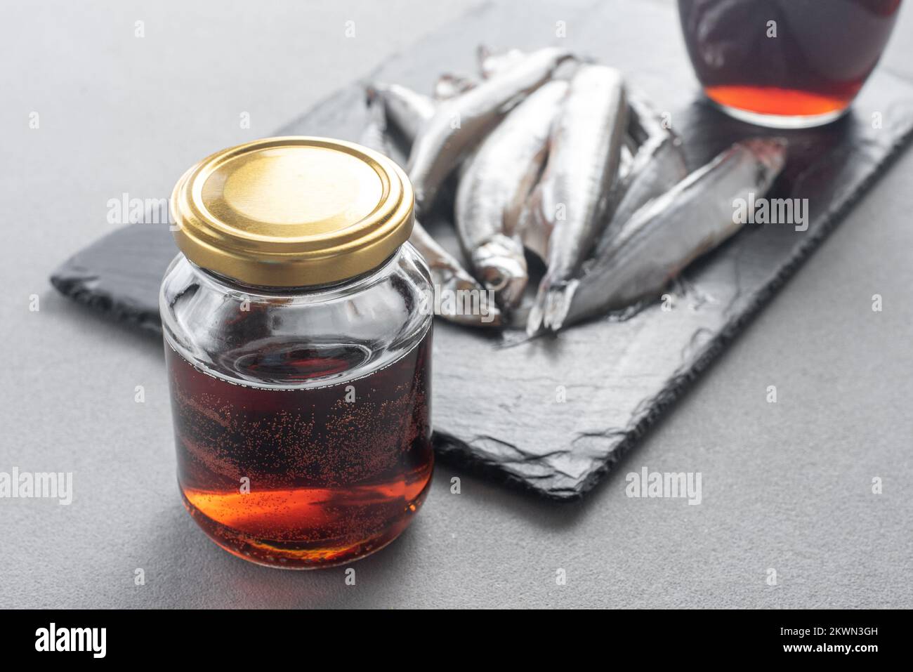 Le Garum est une sauce de poisson fermentée. Préparé par fermentation à partir de poisson, sauce au garum salée dans une bouteille sur fond gris. Sauce au poisson Garum à base de Banque D'Images