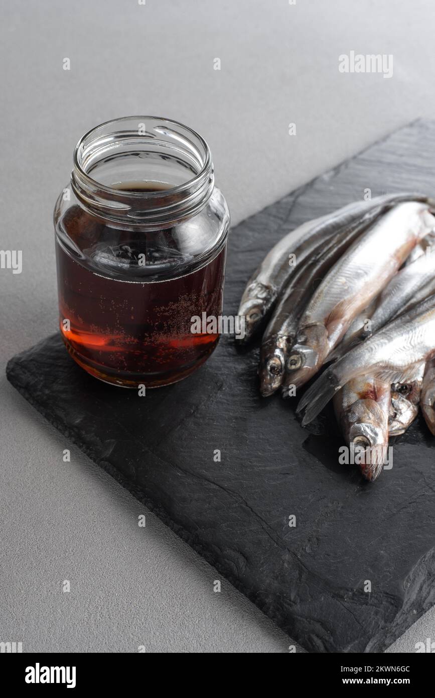 Le Garum est une sauce de poisson fermentée. Préparé par fermentation à partir de poisson, sauce au garum salée dans une bouteille sur fond gris. Sauce au poisson Garum à base de Banque D'Images