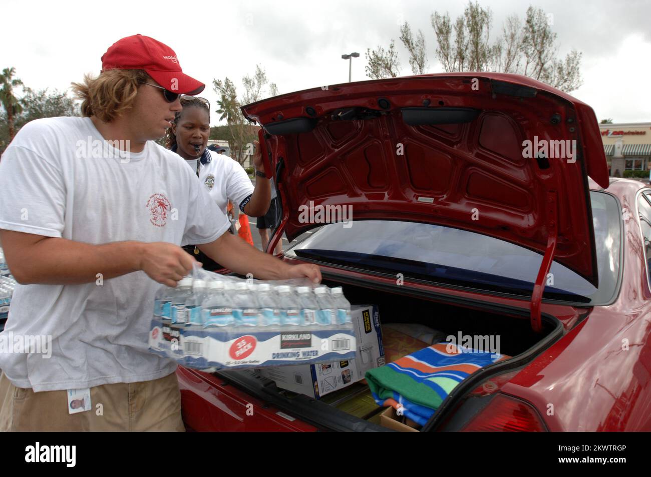 L'ouragan Wilma, Hollywood, FL, 1 novembre 2005 le volontaire William White, un sauveteur de la piscine communautaire de Driftwood, aide à charger de la glace et de l'eau dans un centre de distribution à Oakwood Plaza pour les résidents touchés par l'ouragan Wilma. Le policier Beverly Perez aide également. Photographies relatives aux programmes, aux activités et aux fonctionnaires de gestion des catastrophes et des situations d'urgence Banque D'Images