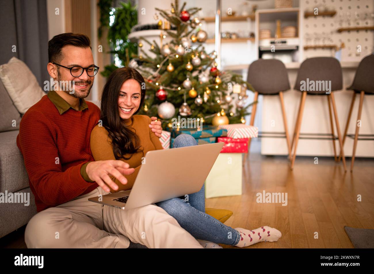 Achats en ligne de Noël. Jeune couple avec ordinateur portable acheter en ligne. Cadeaux de Noël et du nouvel an. e-shopping Banque D'Images